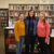 Student tax volunteers pose in front of the library stacks